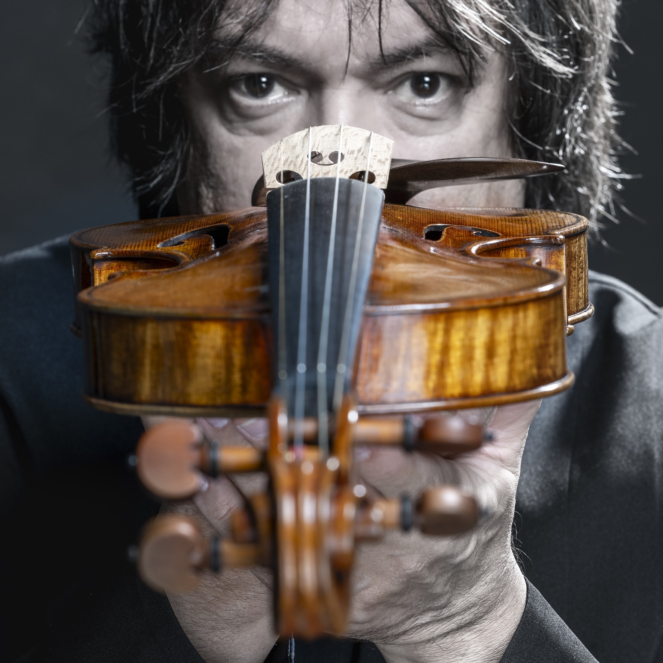 Sergej Krylov looking over his violin, portrait by Cristian Chiodelli